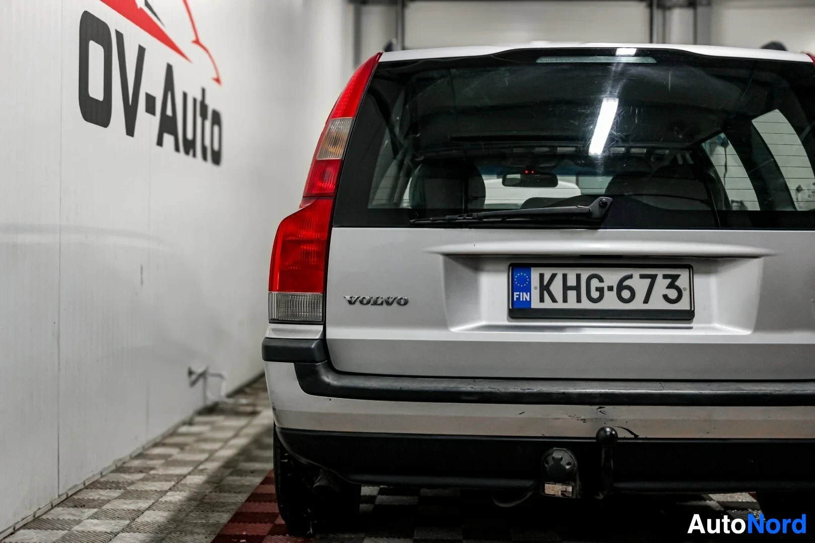 Takaa: Volvo V70 farmariauton takaosa, jossa näkyy peräluukku, takavalot ja rekisterikilpi. Takaluukun alaosassa on vetokoukku