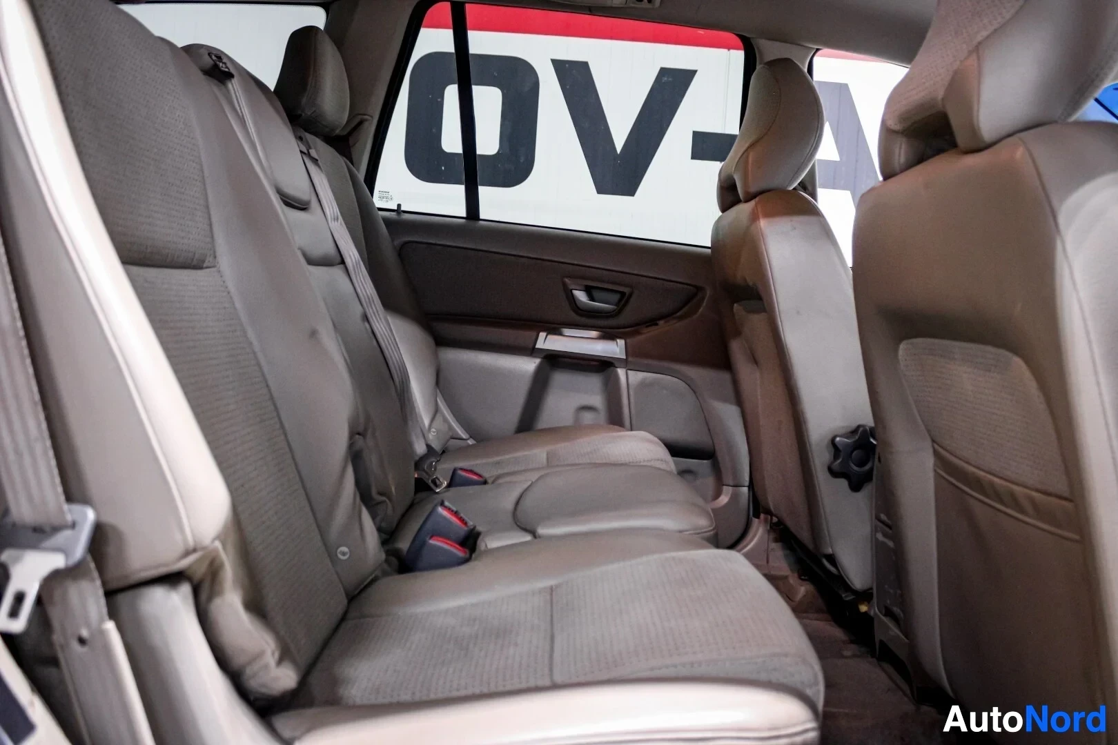 Takaistuimet: Kuvassa näkyy auton takapenkkirivi. Keskellä takapenkkiä on leveämpi istuinosa ja sen molemmin puolin kaksi kapeampaa istuinta, joissa näkyy turvavyöt.
