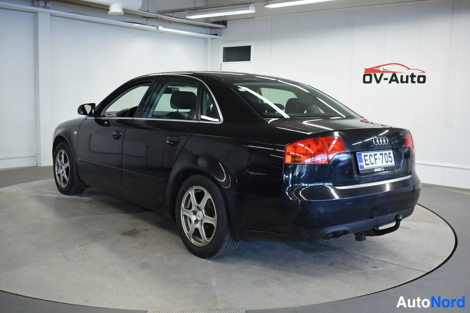Takaviisto: Musta Audi A4:n takaosa ja vasen kylki kuvattuna hieman takaviistosta. Autossa on vetokoukku.
