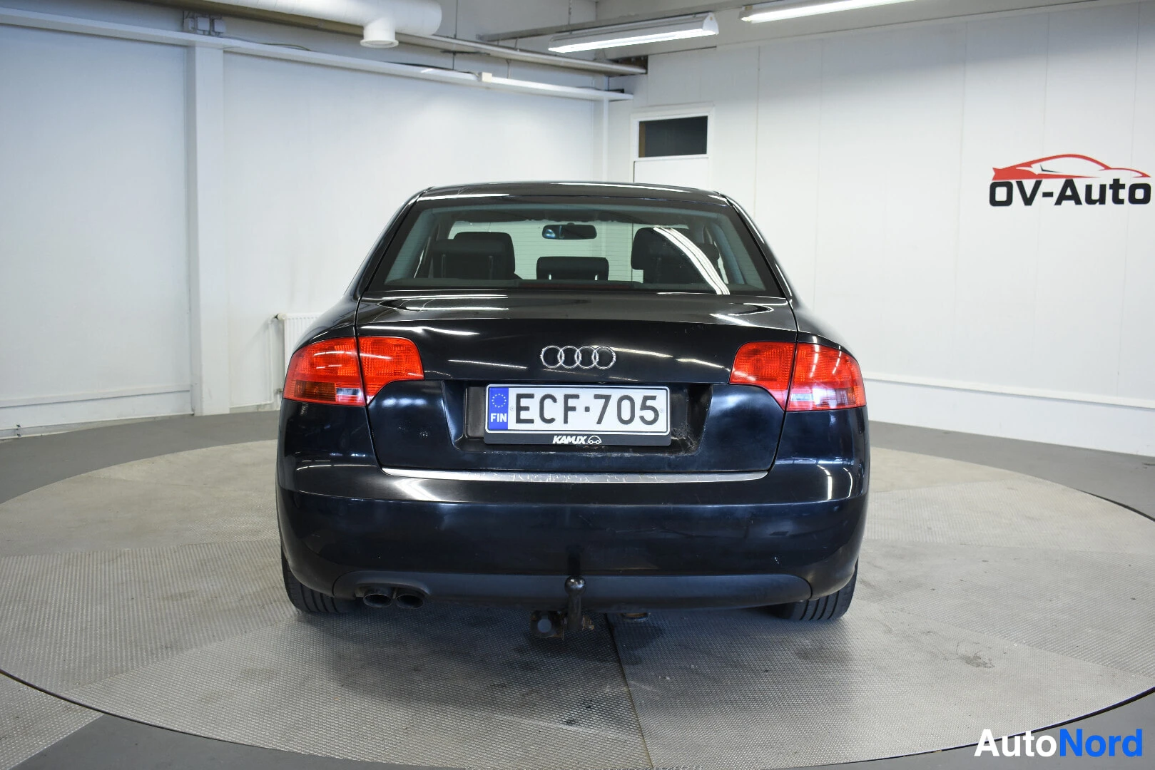 Takaa: Mustan Audi A4:n perä, jossa on vetokoukku. Rekisterikilpi on