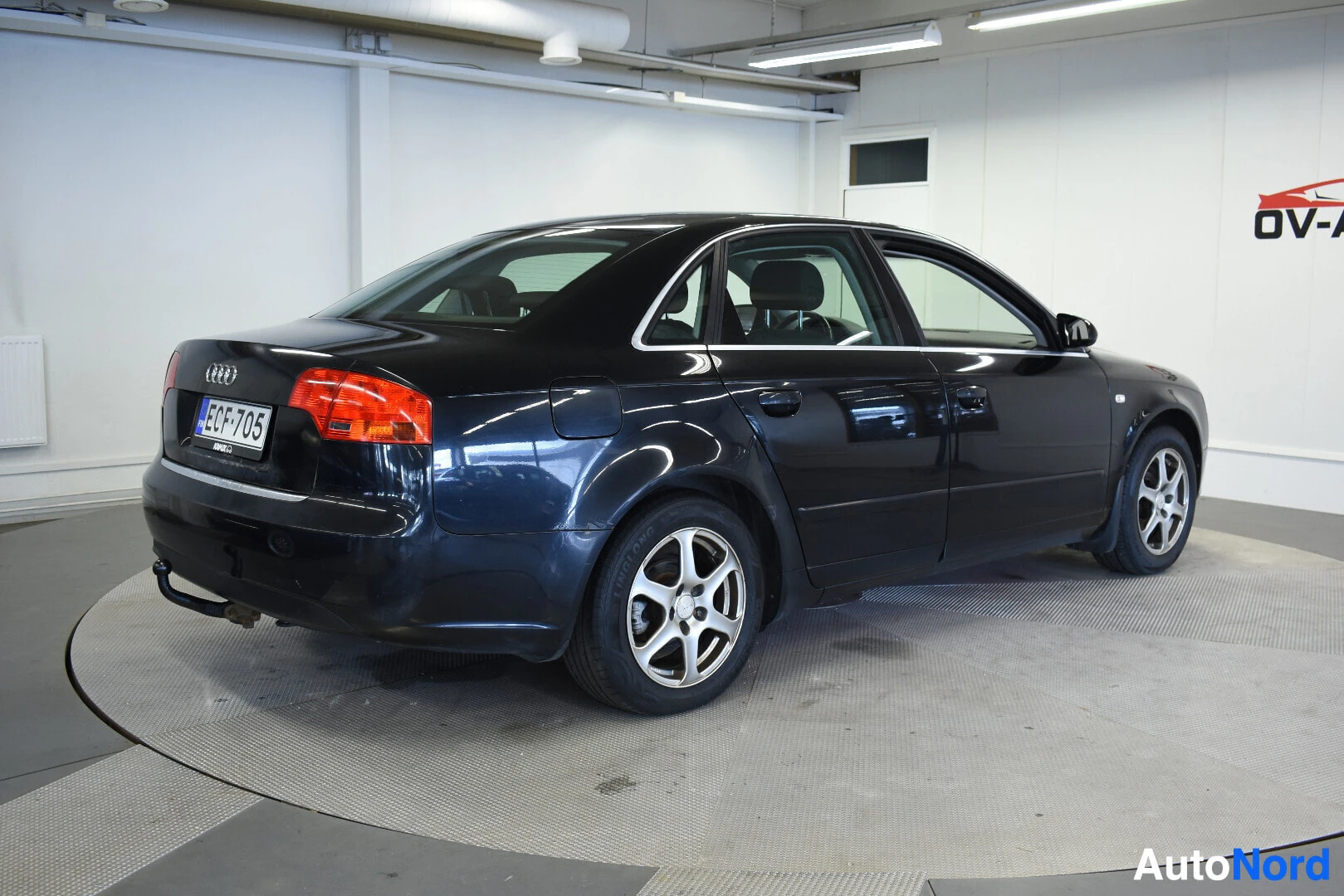 Takaviisto: Mustan Audi A4:n takaosa ja oikea kylki kuvattuna hieman takaviistosta. Autossa on vetokoukku.