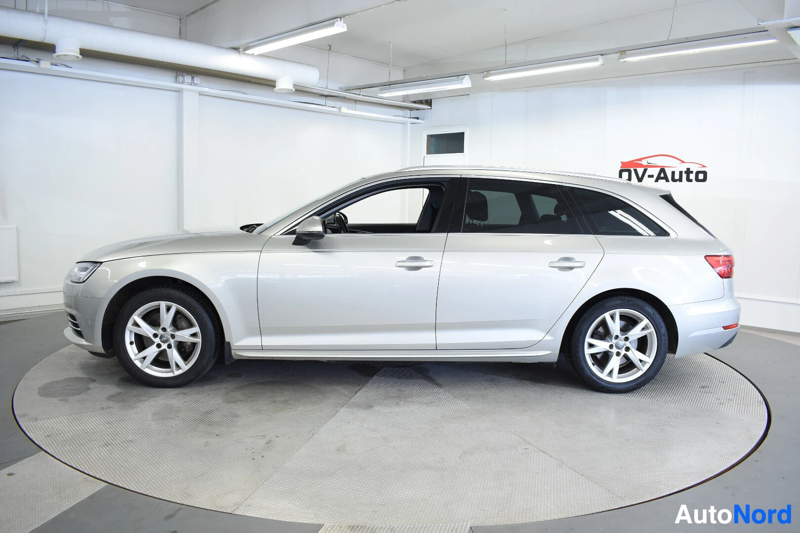Sivulta: Hopeanvärinen Audi A4 Avant -farmariauto kuvattuna kyljestä. Autossa on viisipuolaiset kevytmetallivanteet.