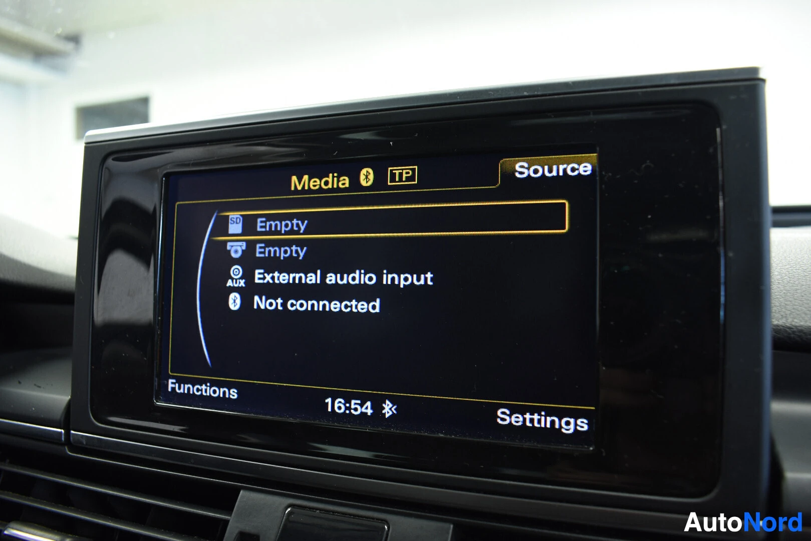 Yksityiskohta: Lähikuva ajoneuvon keskikonsolin näytöstä, joka näyttää 'Media' ja 'Source' valikot, sekä 'External audio input' ja 'Not connected' tekstit. Kellonaika näytöllä