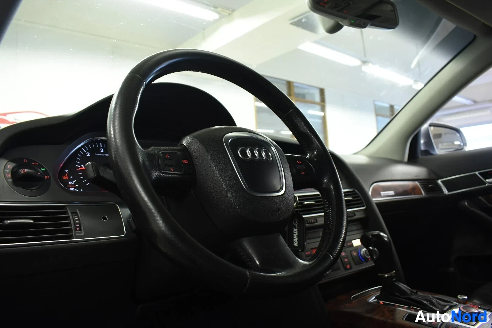 Ohjaamo: Kojelauta ja ohjauspyörä on kuvattu auton oikealta puolelta. Ohjauspyörä on käännetty oikealle ja sen taustalla näkyy mittaristo. Keskikonsolissa näkyy infotain