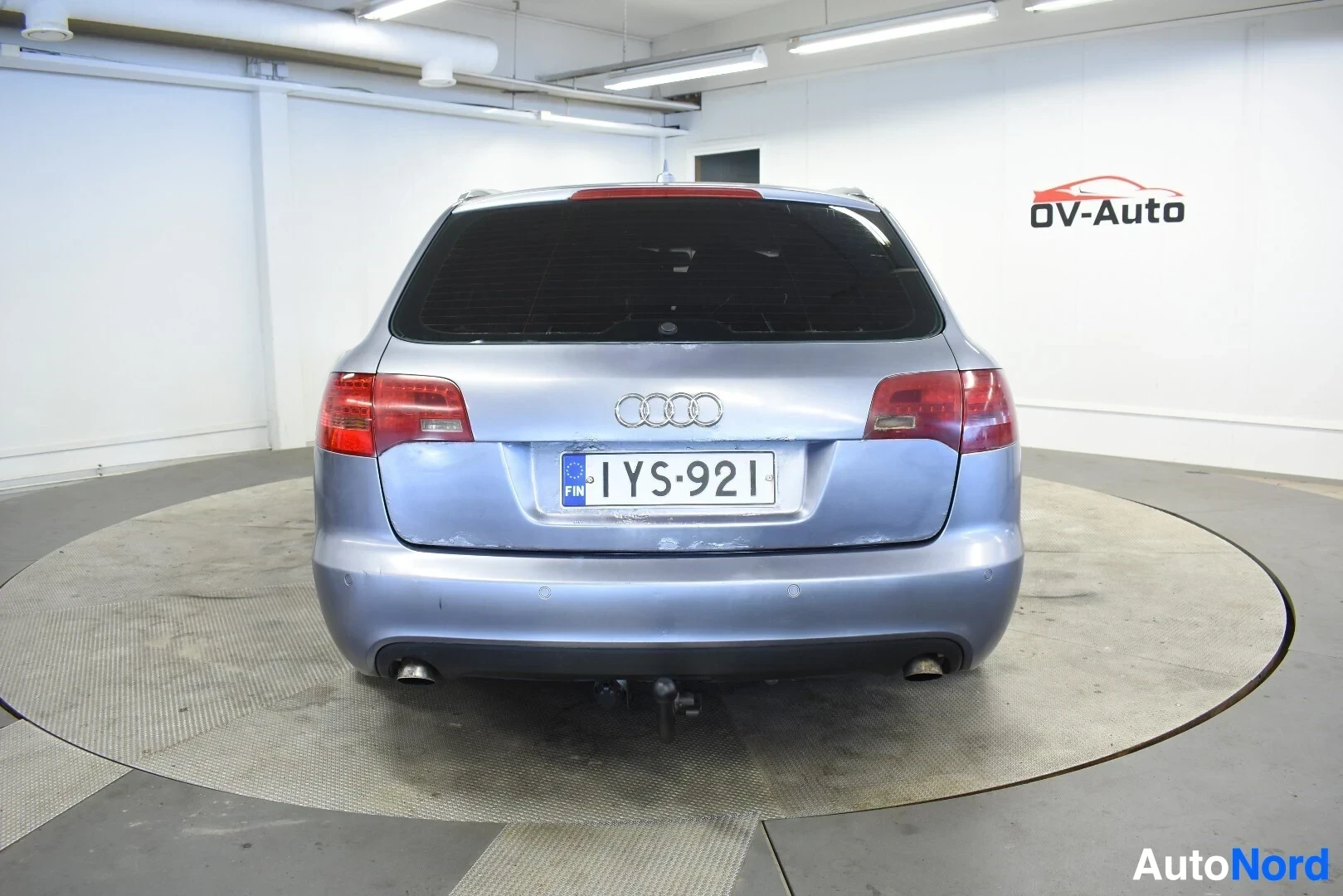 Takaa: Vaaleansininen farmariauto takaapäin kuvattuna. Autossa on vetokoukku ja parkkitutkan anturit takapuskurissa.