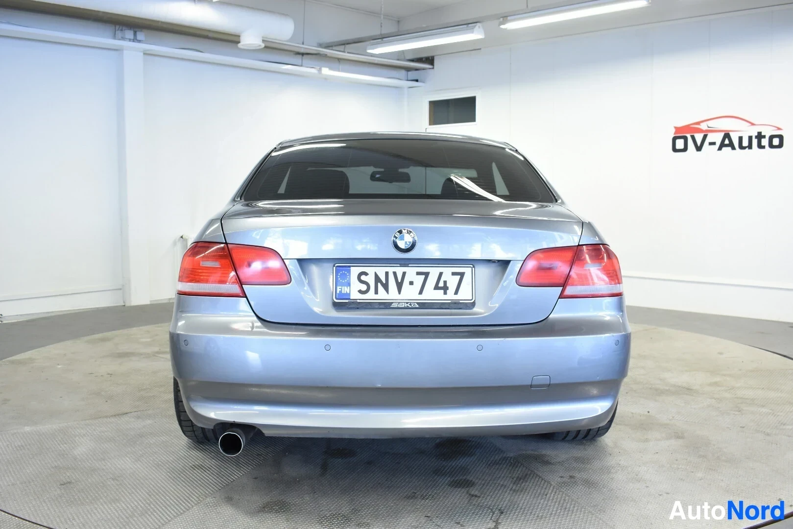 Takaa: Harmaa BMW:n coupé kuvattuna suoraan takaa. Autossa on yksittäinen pakoputki ja rekisterinumero