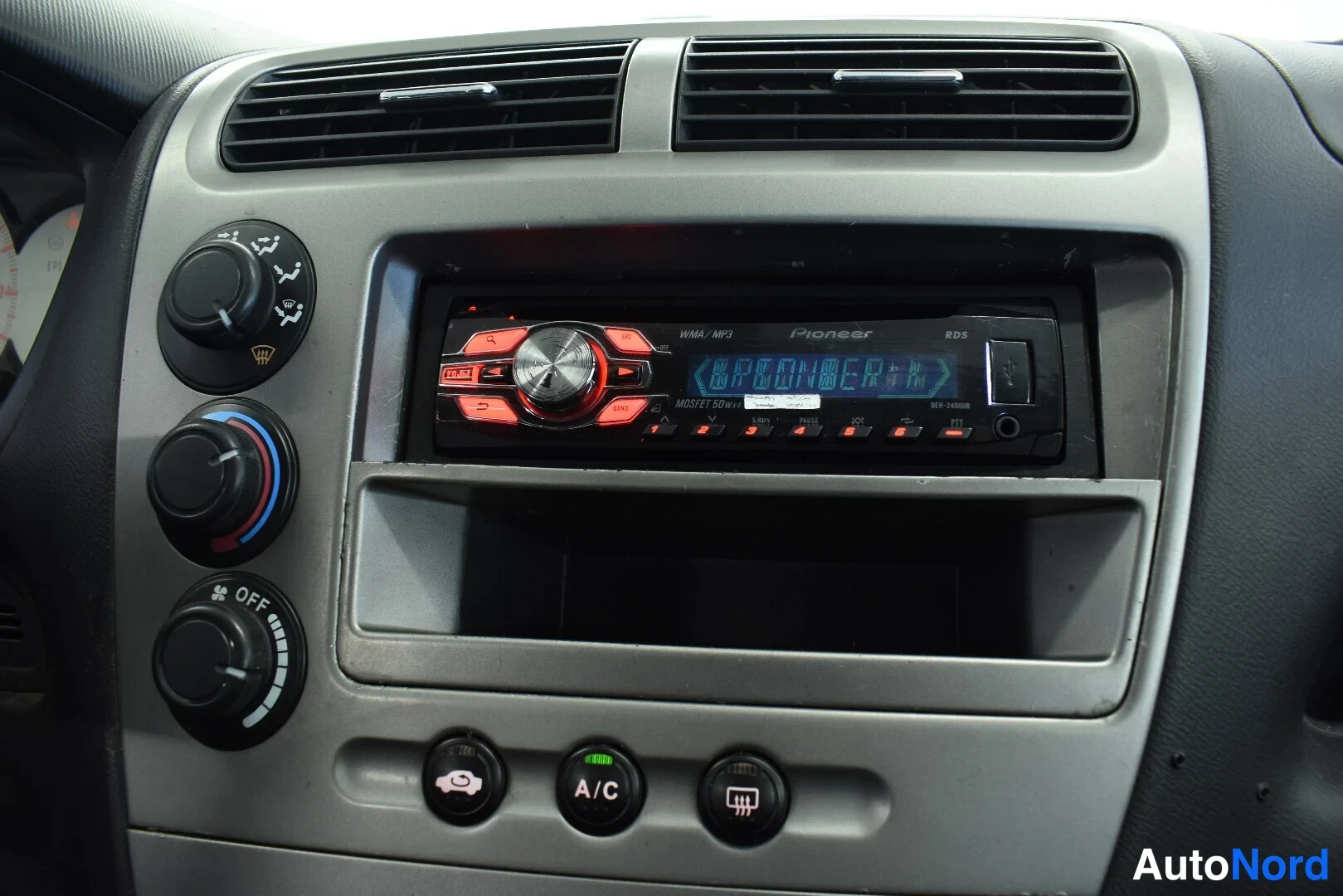 Muu: Kojelaudan keskusta: Pioneer-radio, ilmastointipainike A/C ja lämpötilan säätökiekot.