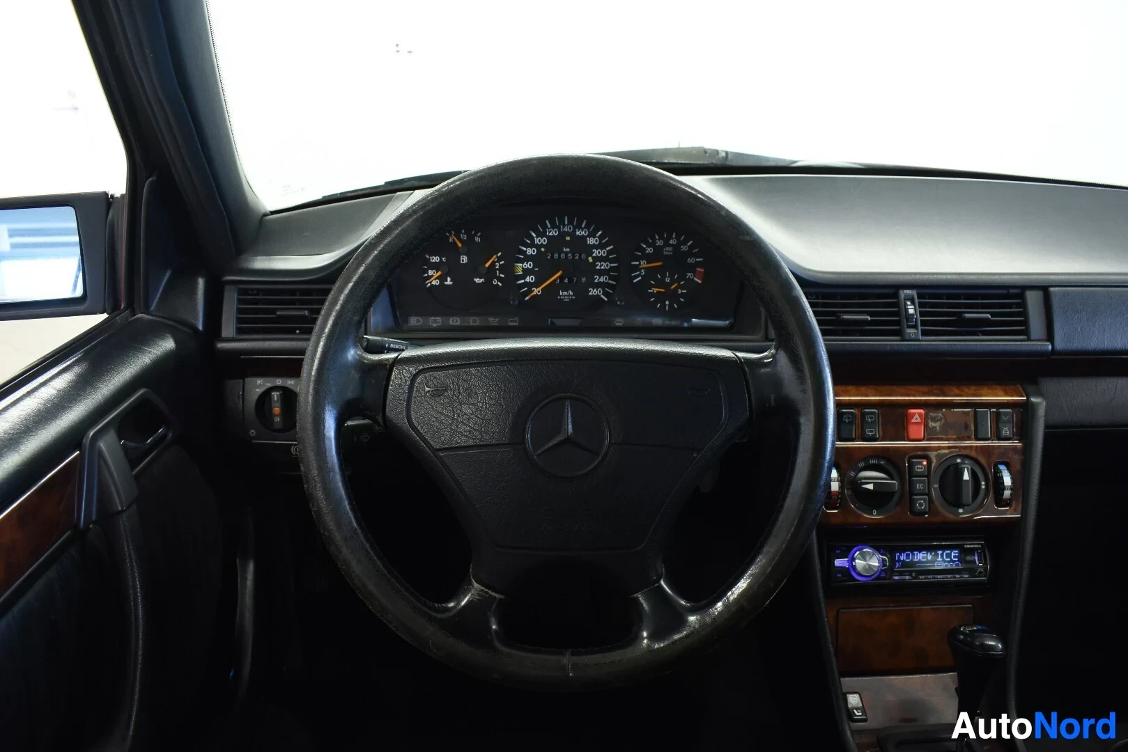 Yksityiskohta: Ohjauspyörä ja mittaristo. Mittaristossa on nopeusmittari, matkamittari ja kierroslukumittari. Ohjauspyörässä on Mercedes-Benz-logo.