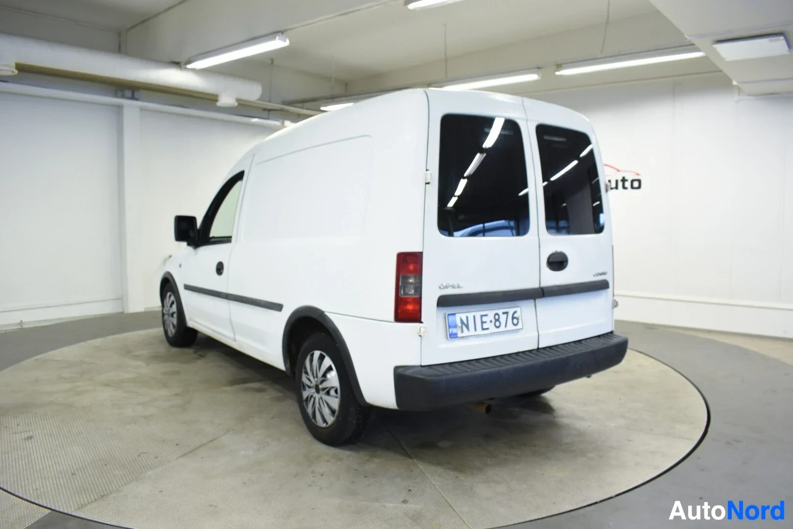 Takaviisto: Valkoinen pakettiauto kuvattuna takavasemmalta. Rekisterikilpi "" on näkyvissä