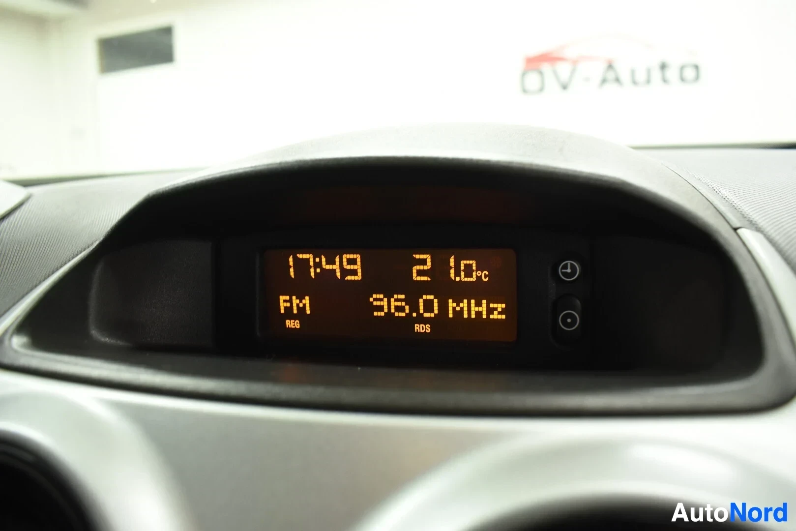 Yksityiskohta: Lähikuva auton keskinäytöstä, jossa näkyvät kellonaika 17:49, lämpötila 21.0°c ja radiotaajuus 96.0 MHz.