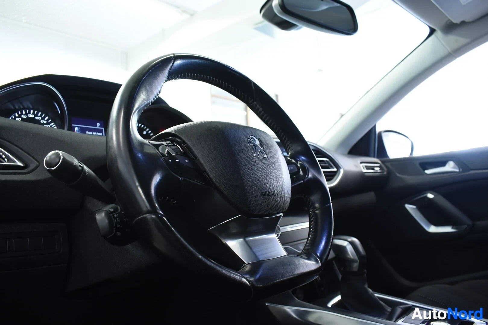 Ohjaamo: Ohjaamon sisäkuva, jossa näkyy kuljettajan puoleinen ohjauspyörä ja osittain kojelauta. Ohjauspyörässä on "AIRBAG"-merkintä.