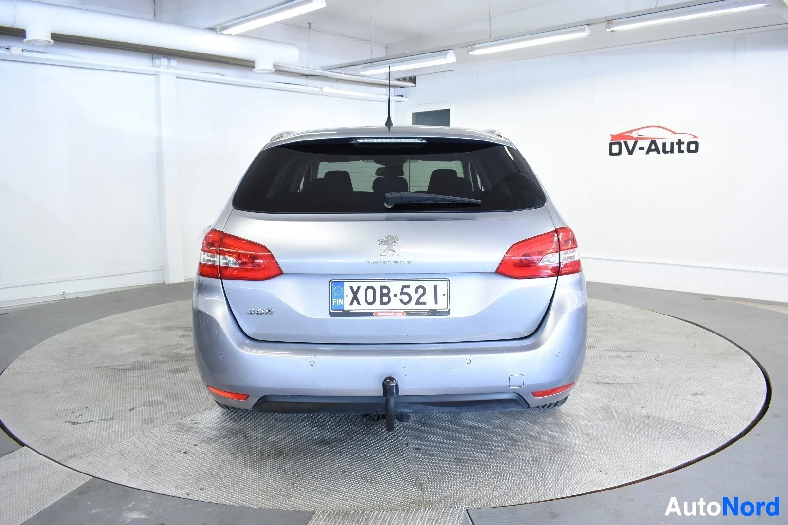 Takaa: Hopeanvärinen Peugeot 308 SW takaa päin kuvattuna. Ajoneuvossa on vetokoukku.