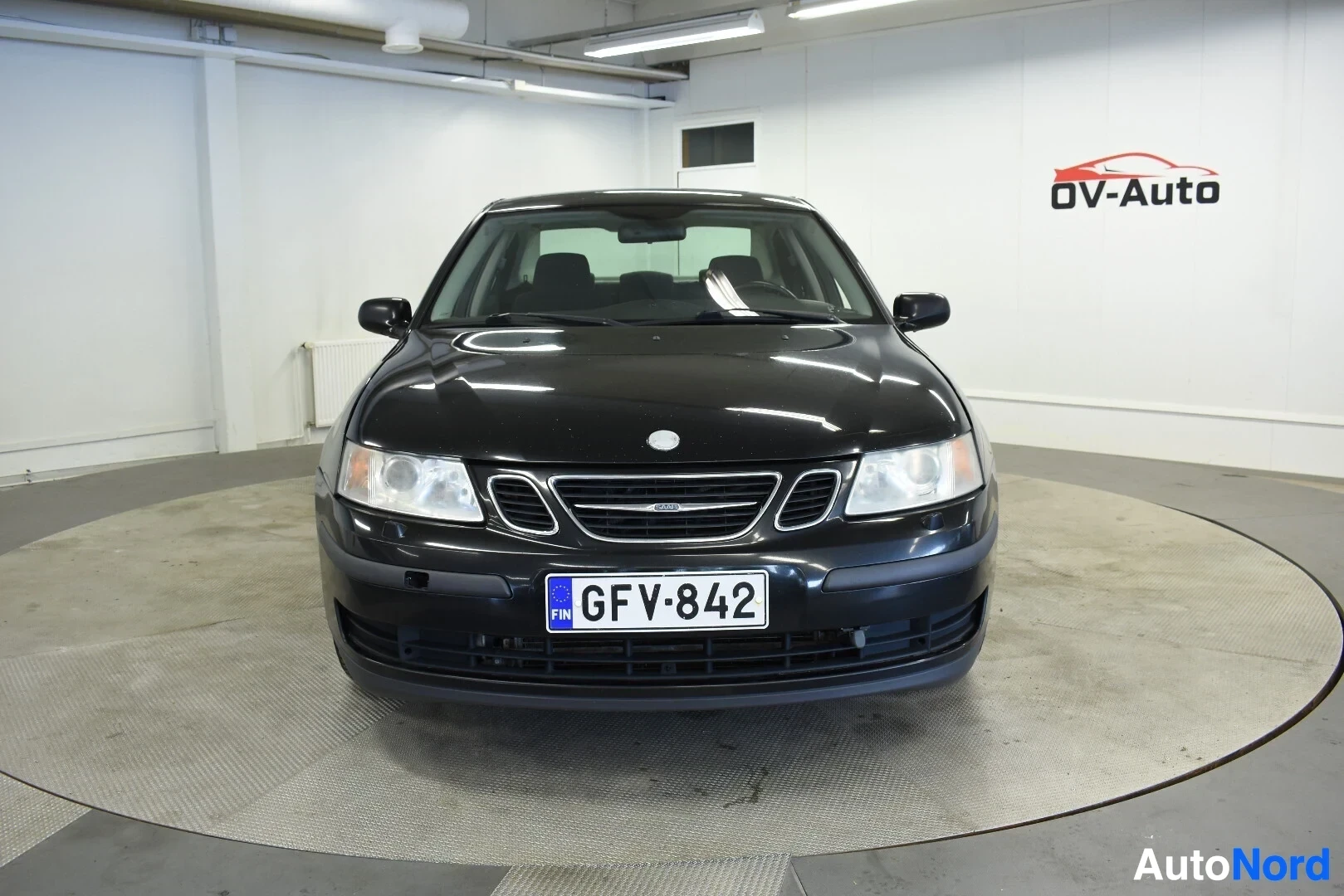 Edestä: Musta Saab 9-3 sedan edestäpäin kuvattuna. Etupuskurissa on suomalainen rekisterikilpi GF V-842.