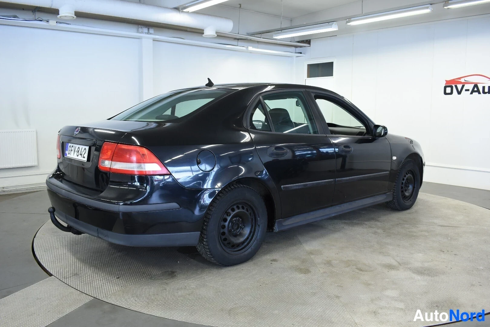 Takaviisto: Musta henkilöauto kuvattuna takaoikealta viistosti. Autossa on koukku ja mustat peltivanteet.