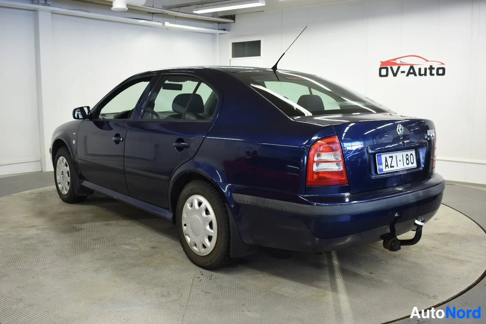 Takaviisto: Tummanpunainen Skoda Octavia -henkilöauto, jossa on vetokoukku, kuvattuna taka-oikealta viistosta.