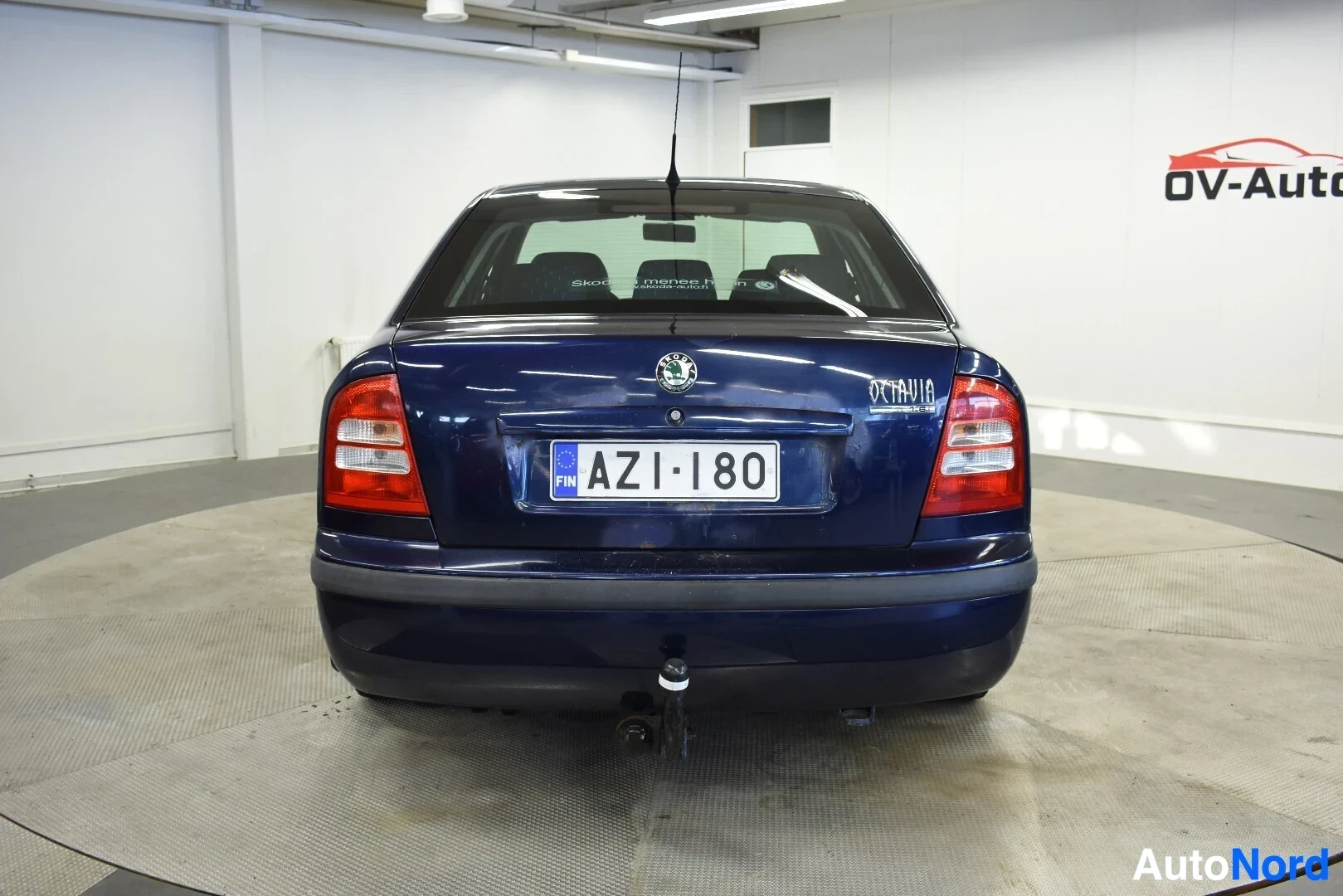 Takaa: Tummanpunaisen Skoda Octavian takaosa, jossa on vetokoukku ja rekisterikilpi