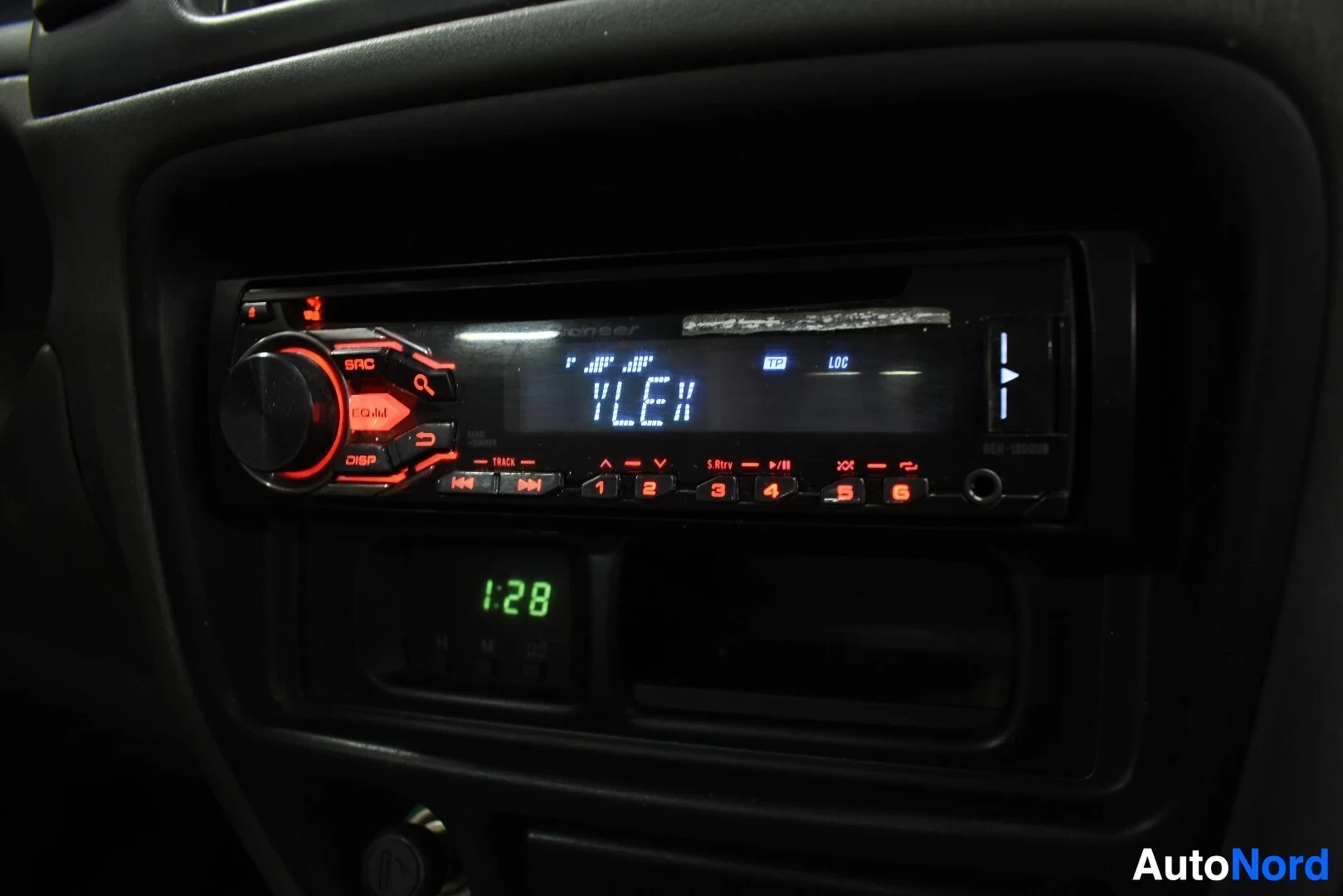Yksityiskohta: Auton radio, jonka näytöllä lukee "YLE".