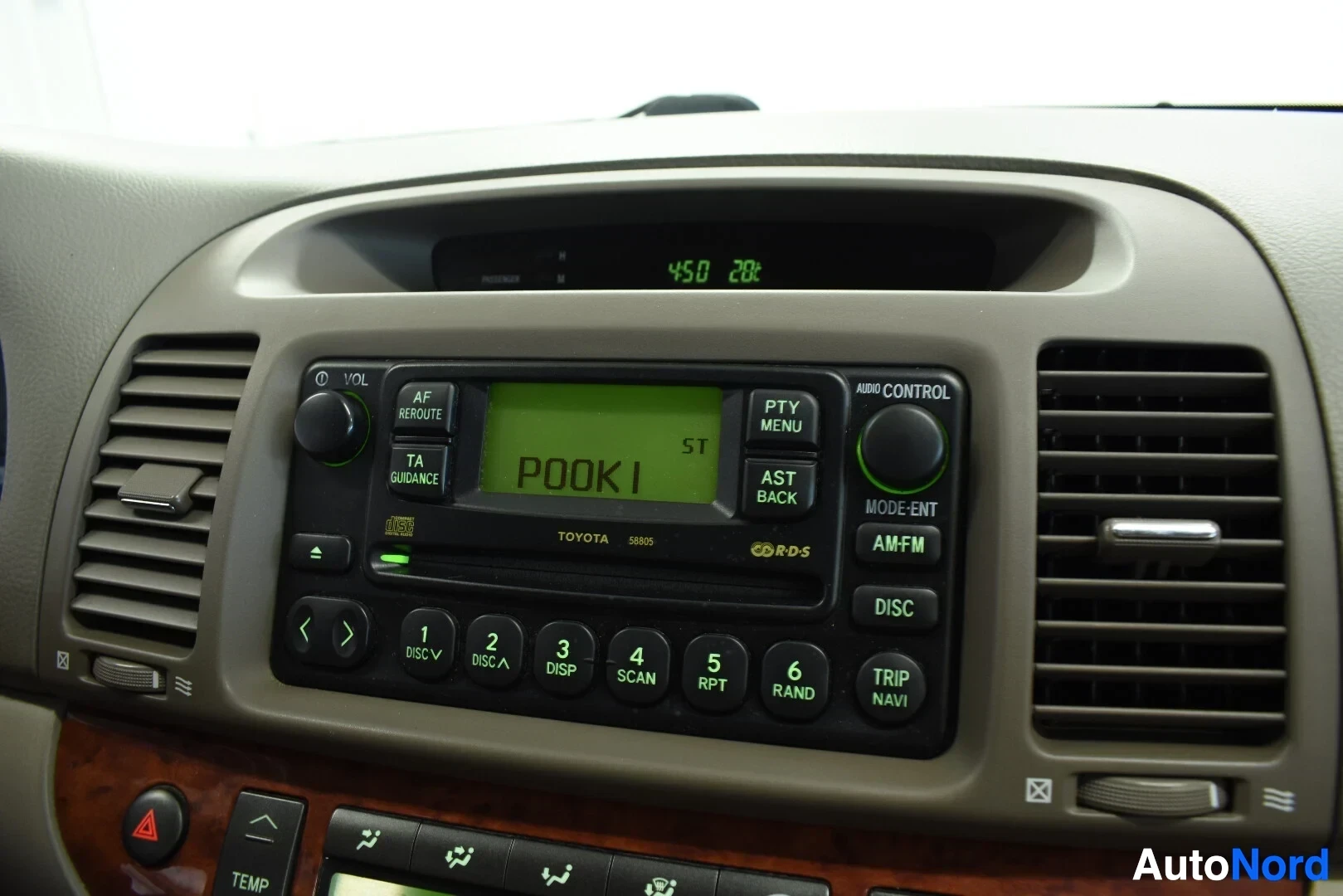 Yksityiskohta: Auton radio/CD-soitin keskikonsolissa, jossa näyttö ja Toyota-brändäys.