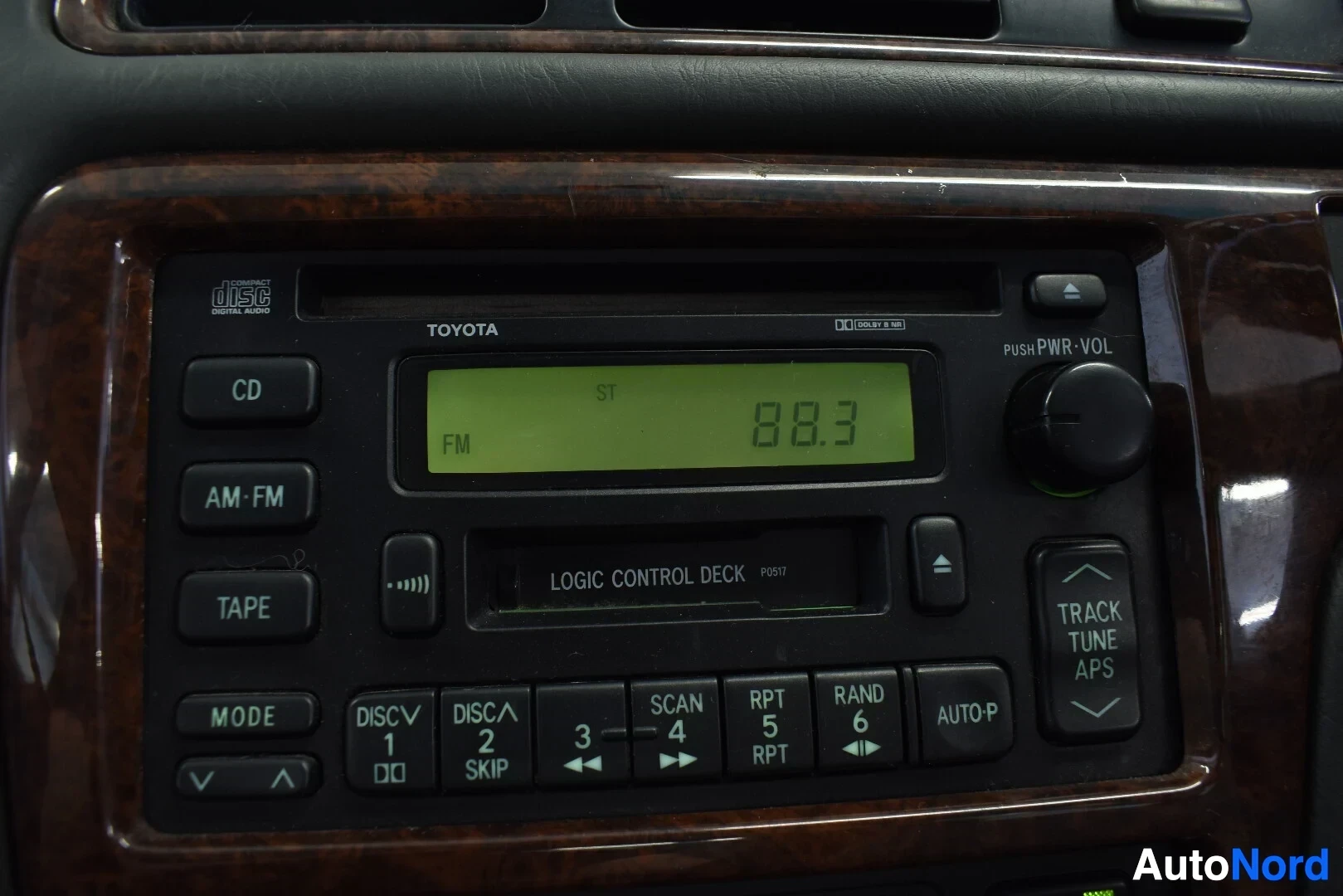 Yksityiskohta: Lähikuva auton integroidusta Toyota-radiosta ja kasettisoittimesta, jossa on myös CD-levynlukija ja näyttö, jossa lukee "88.3".