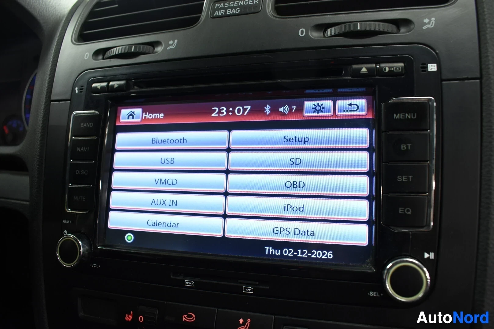 Ohjaamo: Lähikuva auton infotainment-järjestelmän näytöstä, joka näyttää aloitusvalikon. Valikossa on painikkeet "Bluetooth", "USB", "VMCD", "AUX IN", "Calendar" vasemma