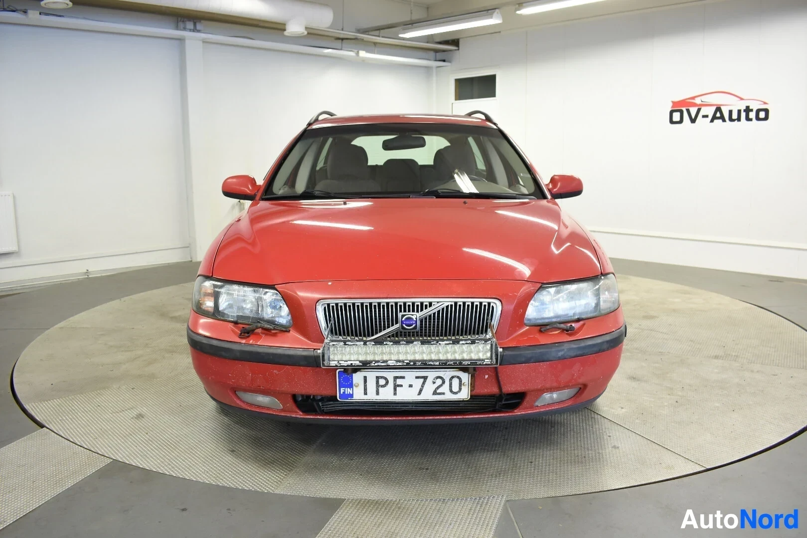 Edestä: Punainen Volvo V70 -farmariauto kuvattuna edestä.