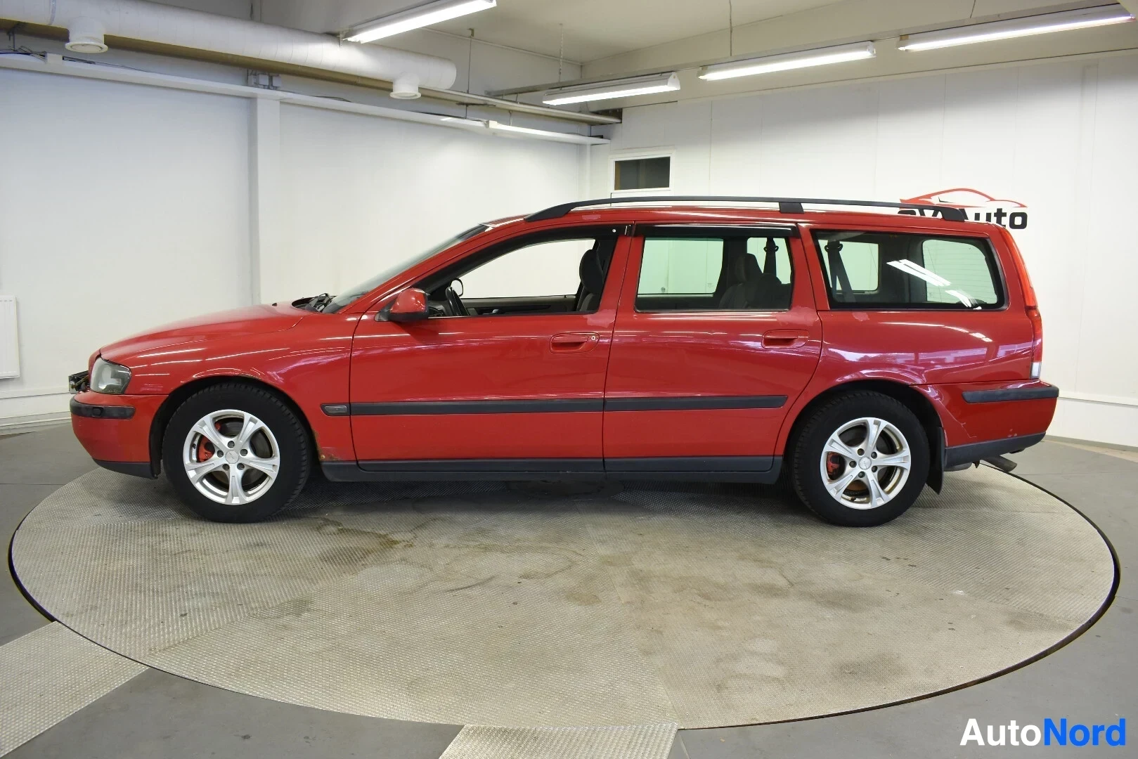 Sivulta: Punainen Volvo V70 -farmariauto kuvattuna vasemmalta sivulta.