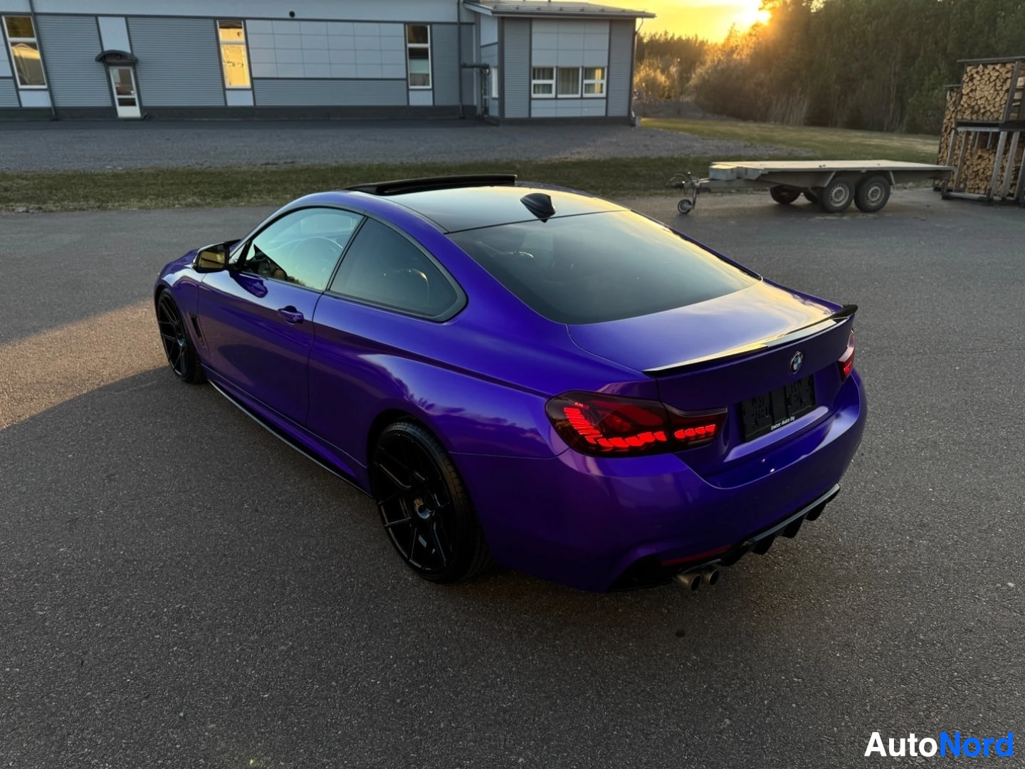 Takaviisto: Violetti kaksiovinen coupé-auto vasemmasta takaviistosta kuvattuna ulkona, auringonlaskun aikaan. Autossa on kattoluukku, mustat monipuolaiset kevytmetallivante