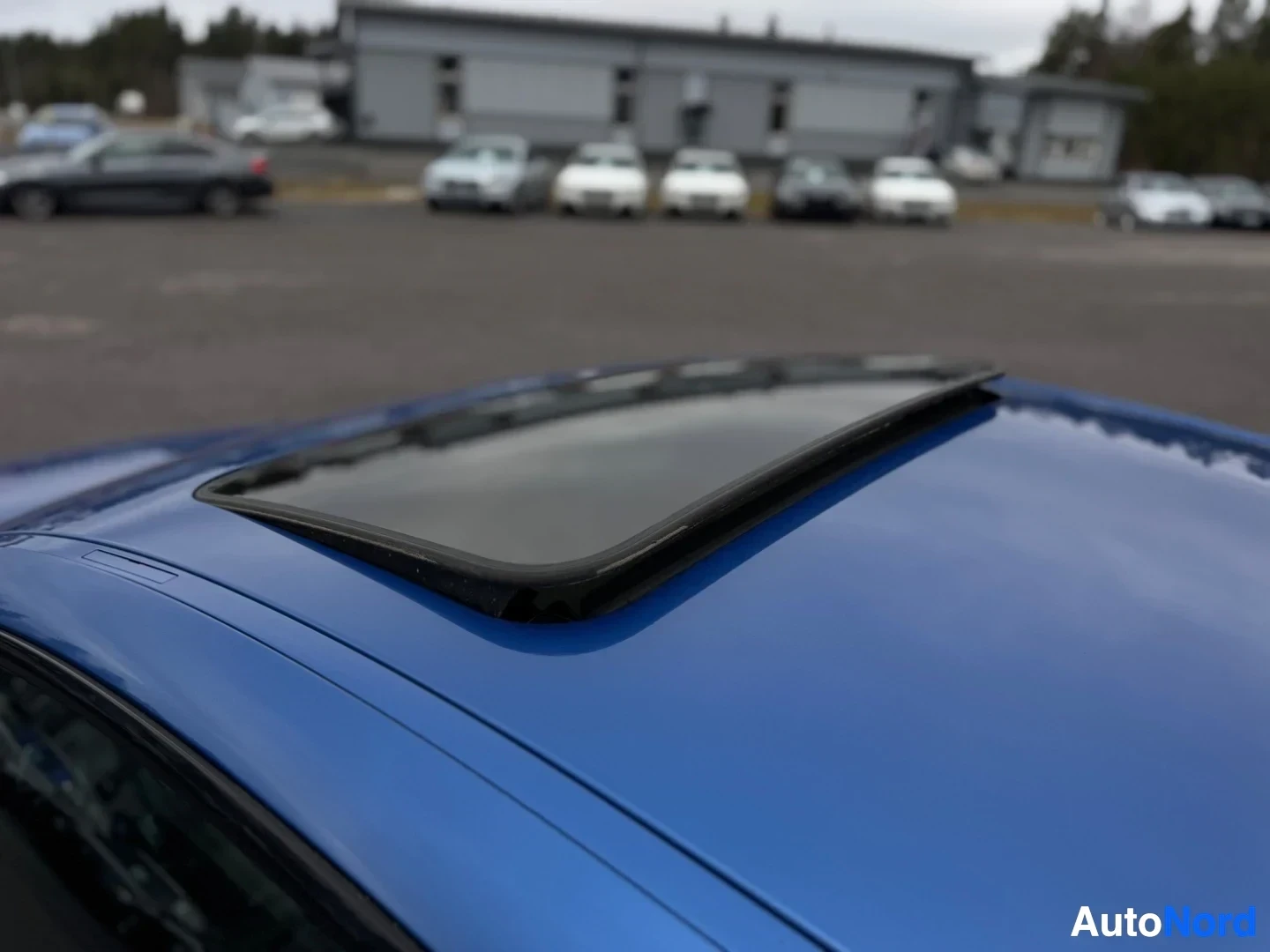 Muu: Lähikuva auton sinisestä katosta, jossa on avoin kattoluukku.