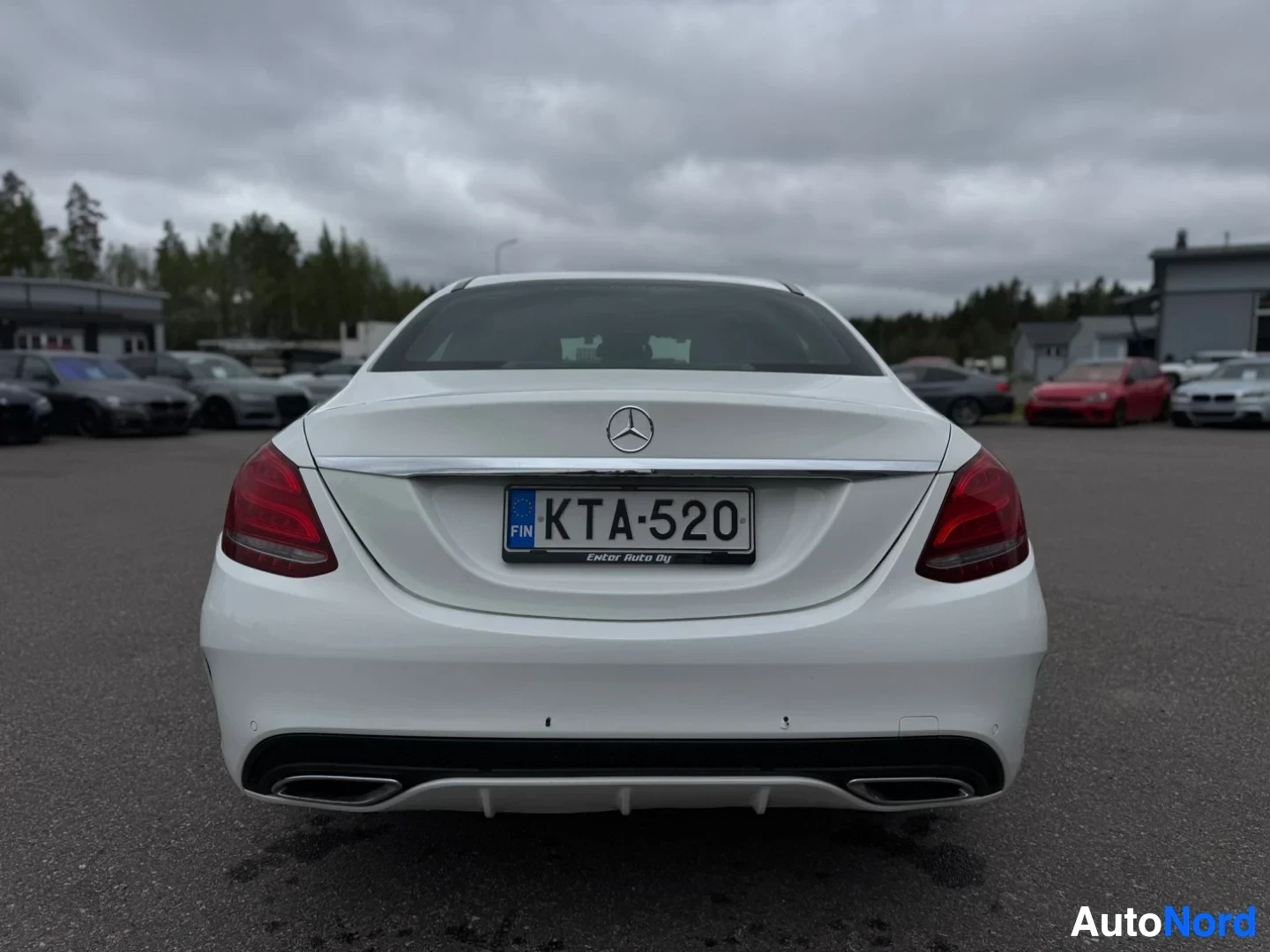 Takaa: Valkoisen sedan-auton takaosa, jossa on rekisterikilpi