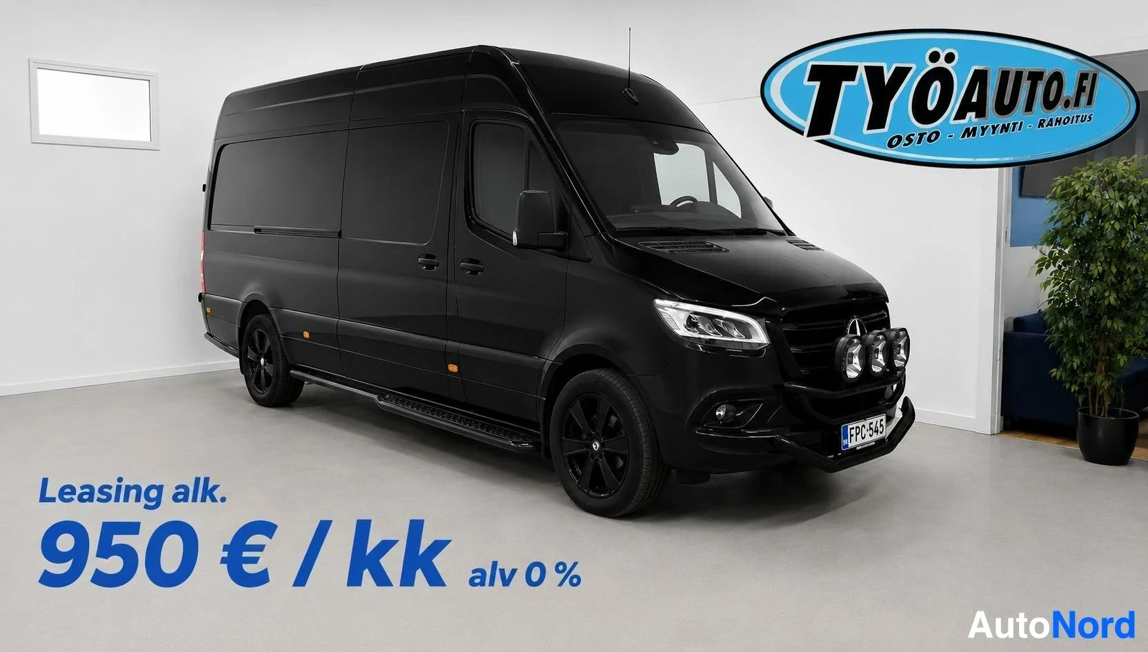 Etuviisto, nokka oikealle: Musta pakettiauto, jossa on lisävalot edessä, seisoo pysäköintihallissa hieman oikealle käännettynä. Rekisterikilpi on "". Kuvan alareunassa on te