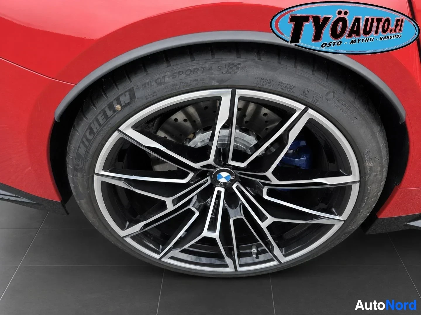 Yksityiskohta: Lähikuva auton renkaasta ja vanteesta. Vanteissa on useita puleita ja renkaissa on Michelin Pilot Sport 4 S -merkintä. Jarrusatula on sininen.
