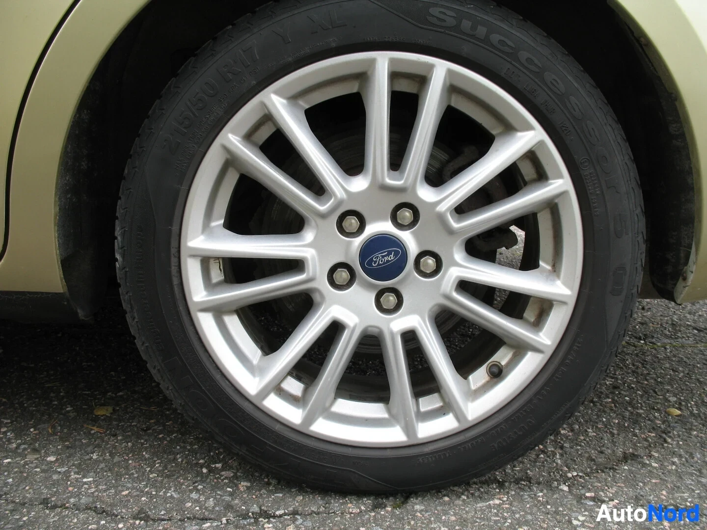Yksityiskohta: Lähikuva auton etupyörästä, jossa on Ford-merkki vanteessa ja Success-merkkiset renkaat.