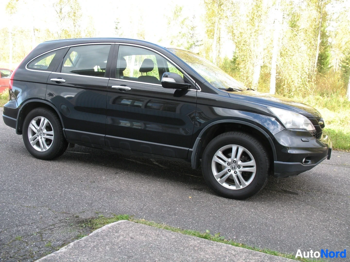 Sivulta: Musta auto kuvattuna vasemmalta sivulta. Vasen kylki, vasen eturengas ja vasen takarengas ovat näkyvissä.