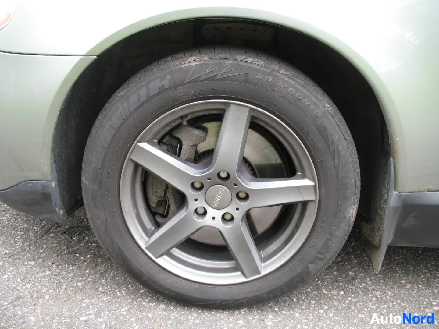 Yksityiskohta: Lähikuva auton harmaasta alumiinivanteesta, jossa on viisi pinnaa ja talvirengas. Renkaan kyljessä lukee "205/60R16" ja "ALLSEASON".