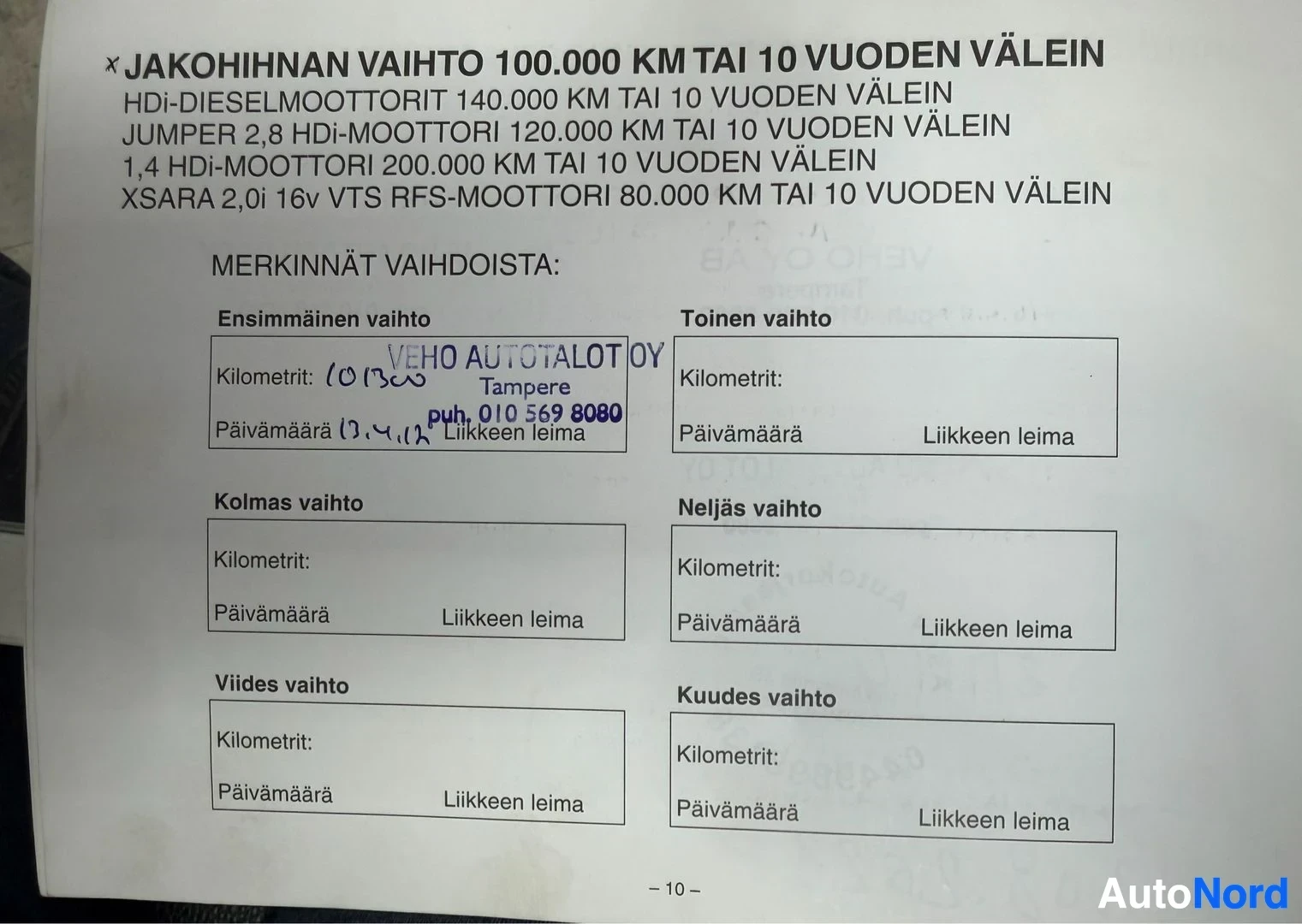 Asiakirja: Lähikuva avoimesta huoltokirjasta, joka sisältää leiman "VEHO AUTOTALOT OY Tampere puh. 010 569 8080" ja käsin kirjoitettuja merkintöjä, kuten kilometrilukeman