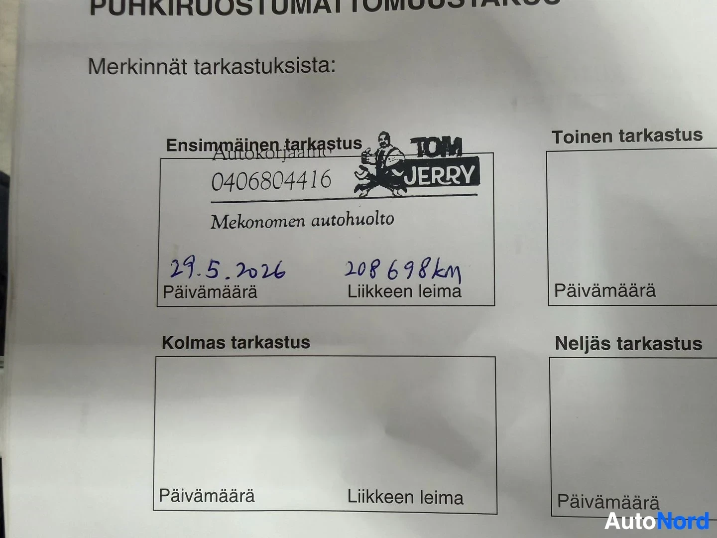 Asiakirja: Lähikuva huoltokirjasta, jossa on merkintä ensimmäisestä tarkastuksesta, jonka päivämäärä on 29.5.2026 ja kilometrilukema 208 698 km, sekä leima "TOM JERRY" ja