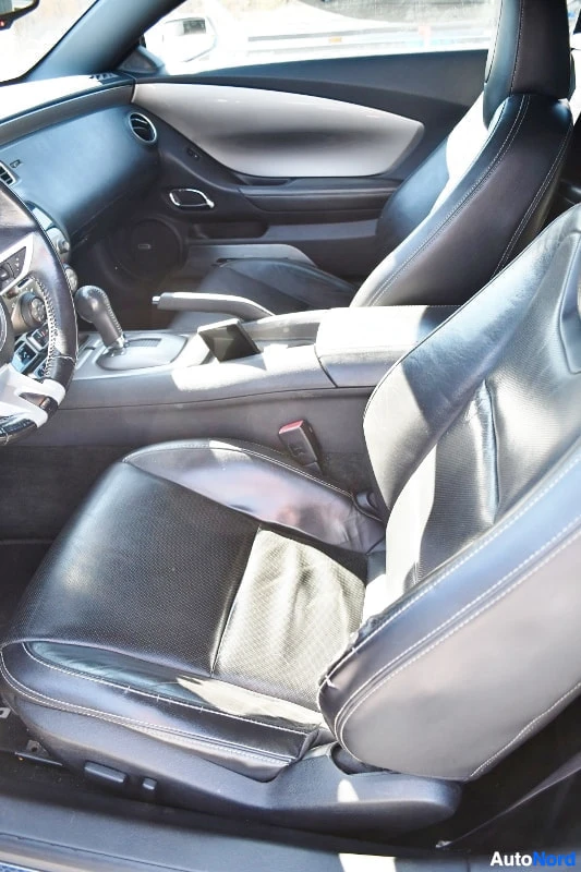 Muu: Mustat nahkaistuimet ja keskikonsoli automaattivalitsimella Chevrolet Camaron sisätiloissa.