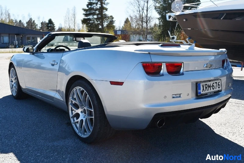 Takaviisto: Hopeanharmaa avo-Chevrolet Camaro takaa kolmannelta; rekisterikilpi, summutus ja perävaunun veto kytkettynä.