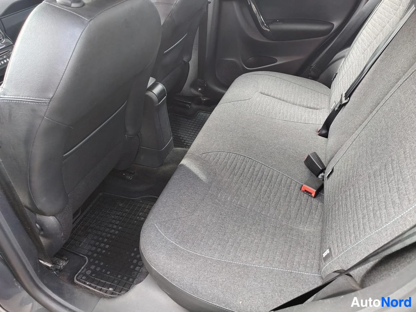 Takaistuimet: Auton takapenkkinäkyvissä kangasverhoillut istuimet ja takatilaa autosta sisältä päin.