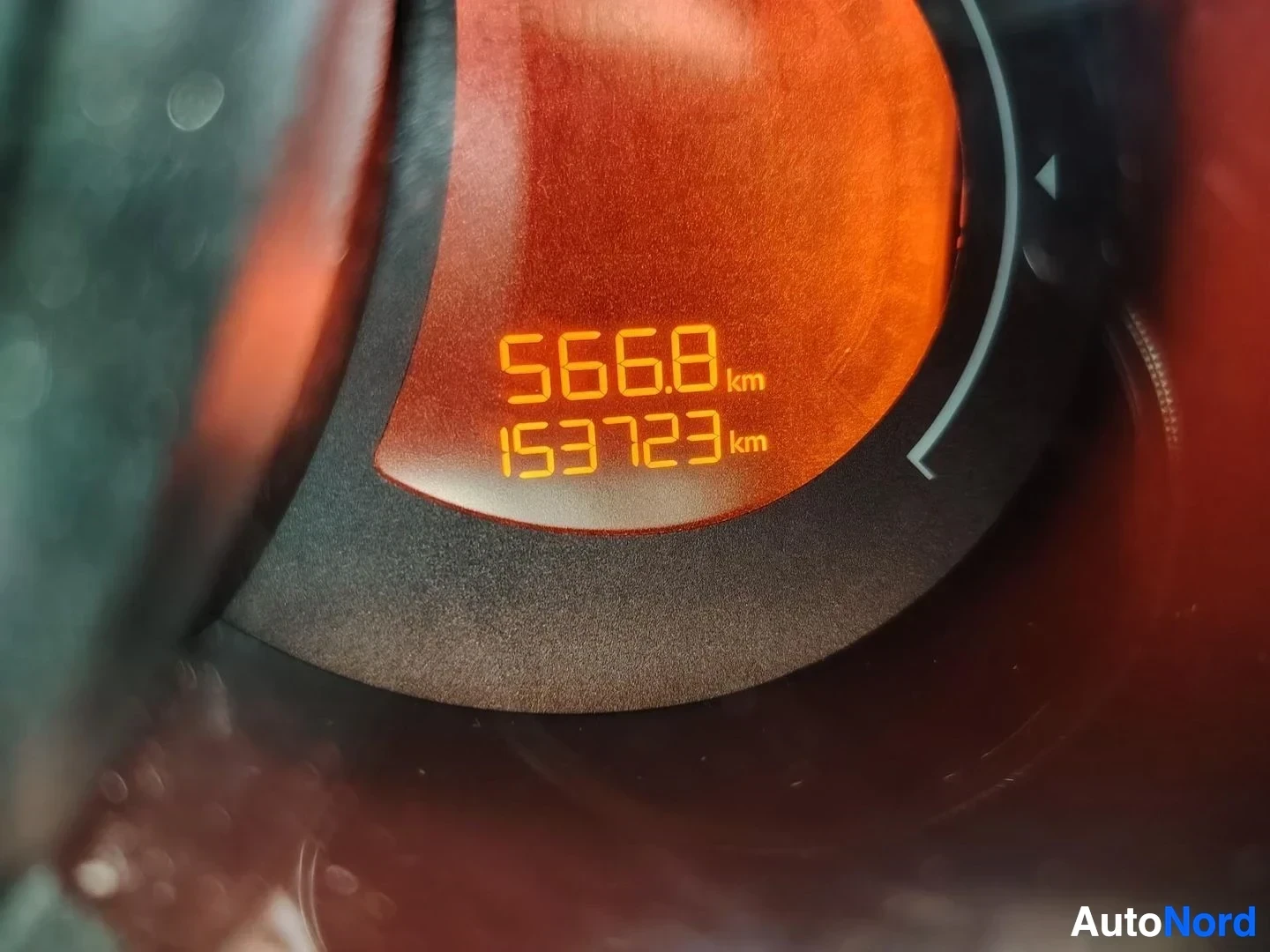 Yksityiskohta: Kojelaudan näytön lähikuva, jossa lukee kokonaismatka 153723 km ja matkakilometrimäärä 566.8 km.