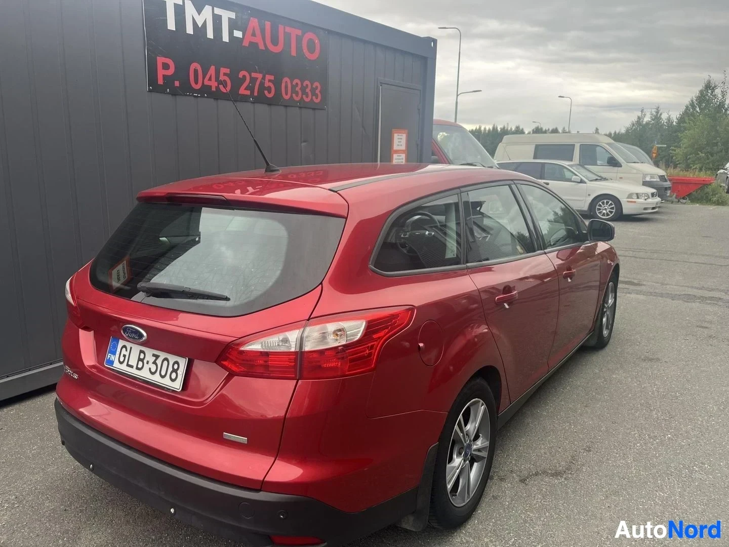 Takaviisto: Punaisen Ford Focus -farmarin takakulmakuva, rekisterikilpi näkyvissä.