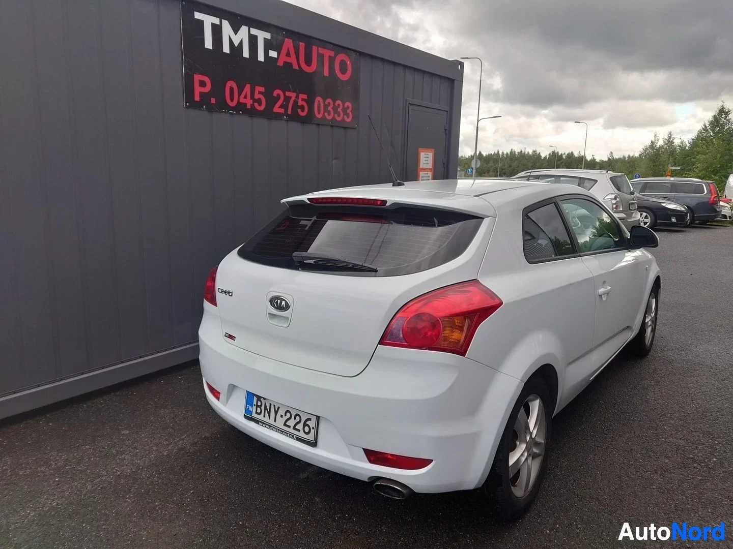 Takaviisto: Kia ProCeed 2008 hopeanvalkoinen takaa kolmannesvinkkelistä; rekisterikilpi, Kia- ja cee'd-merkinnät takaluukussa.