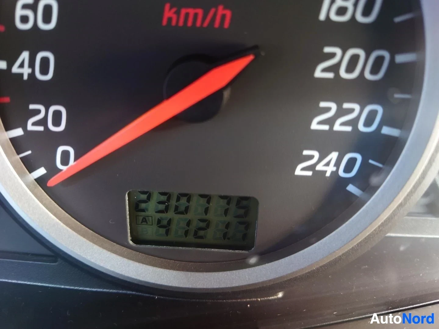 Yksityiskohta: Nopeusmittarin Close-up: asteikko 0–240 km/h ja digitaalinen matkamittarinäyttö