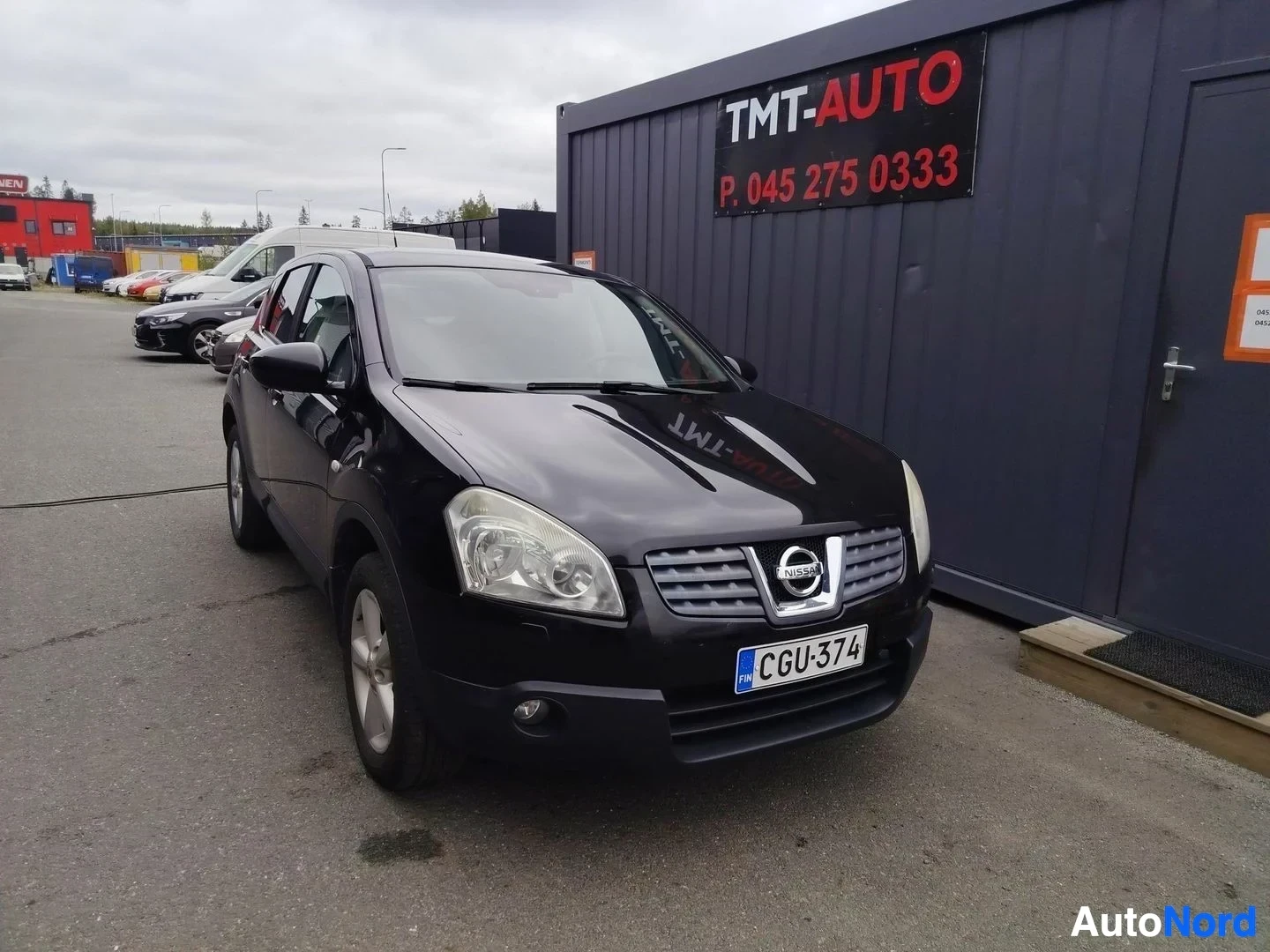Etuviisto, nokka oikealle: Mustan Nissan Qashqain etukolmannelssonuomi-oikea, keulagrilli Nissan-merkki ja rekisterikilpi.