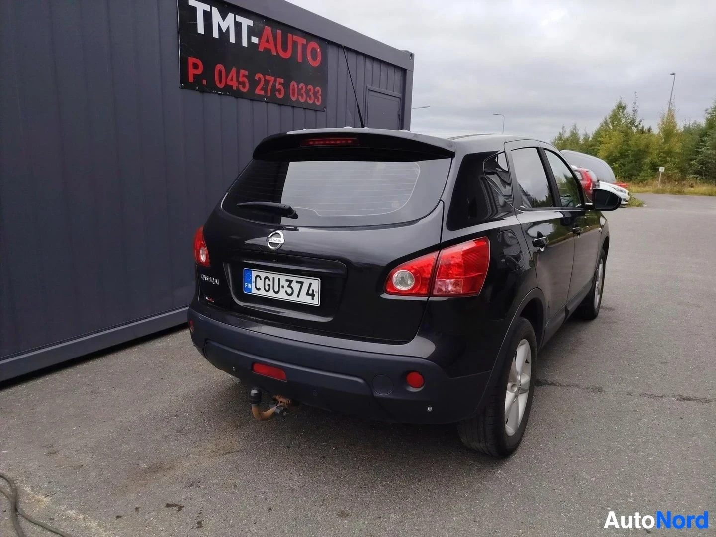 Takaviisto: Mustan auton takakulma vasemmalta: takavalot, Nissan-merkki ja rekisterikilpi näkyvät, takaosassa hinauskytkin.