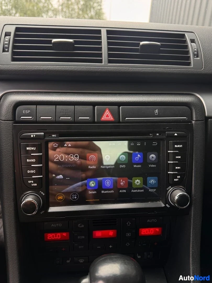 Muu: Kojelaudan keskiosa: kosketusnäyttö jossa Radio, Navigation, DVD, Music ja Video -valikot sekä AUTOnapit ja ilmastointipaneeli näytöillä 20,0 °C.