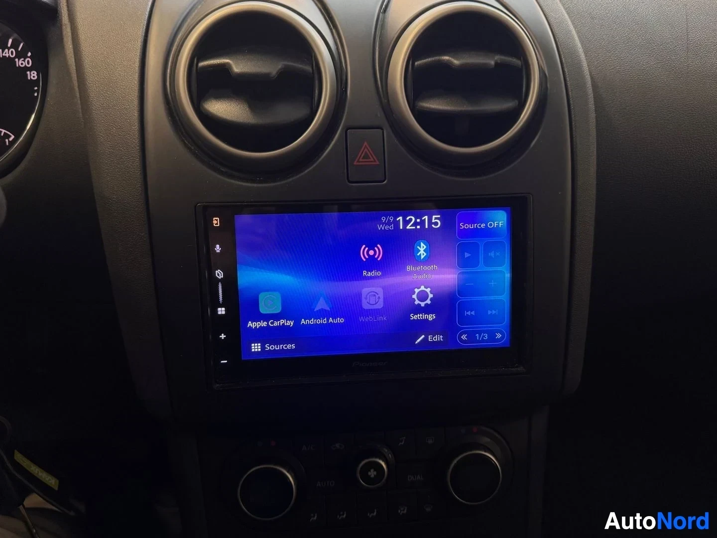 Muu: Kojelaudan keskusta: kaksi pyöreää ilmastointisuutinta ja Pioneer-viritysaudio, jonka näytöllä Apple CarPlay-, Android Auto- ja Radio-kuvakkeet.