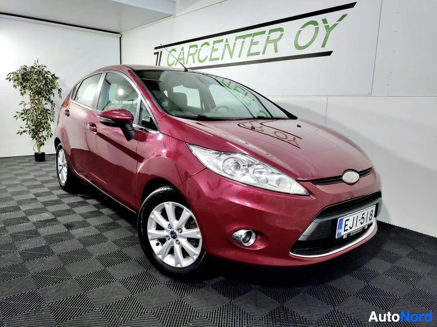 Etuviisto, nokka oikealle: Punainen Ford Fiesta viistoperä etukulmasta oikealta, rekisteri