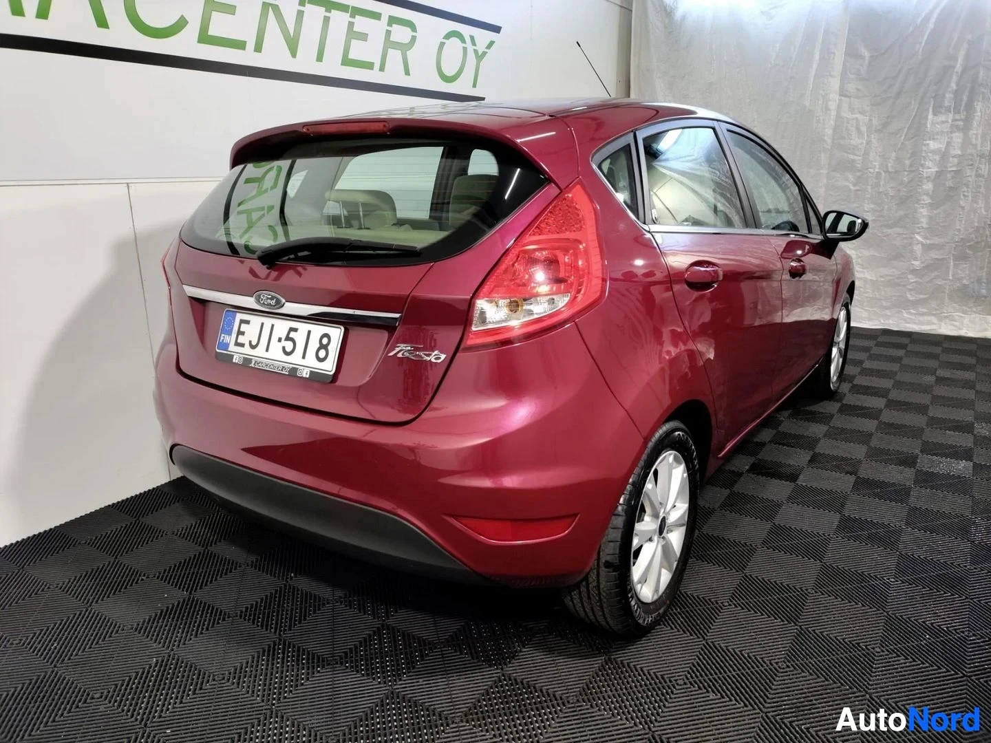 Takaviisto: Punainen Ford Fiesta viistoperä takakulmasta vasemmalta