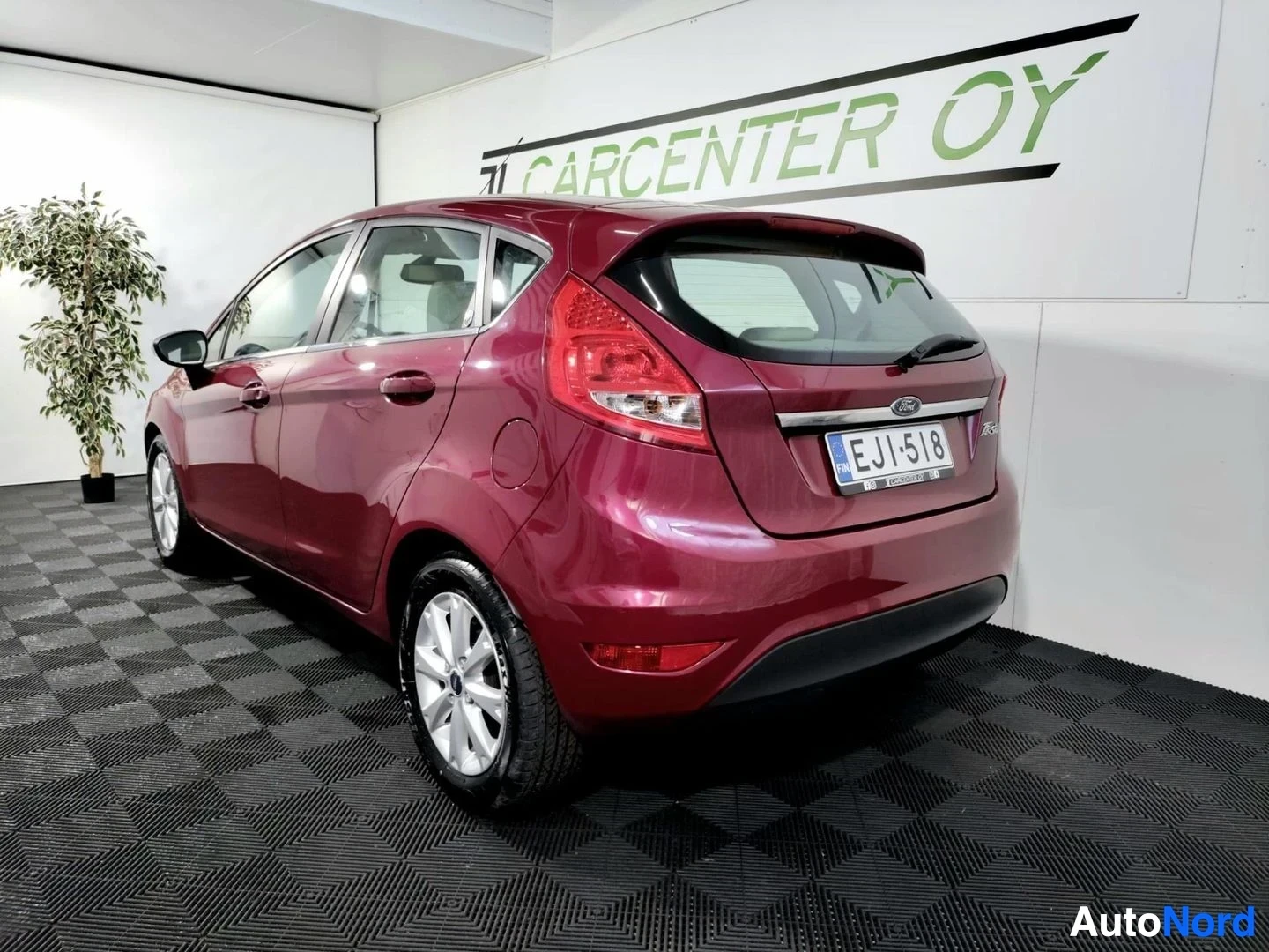 Takaviisto: Punainen Ford Fiesta viistoperä takakulmasta vasemmalta